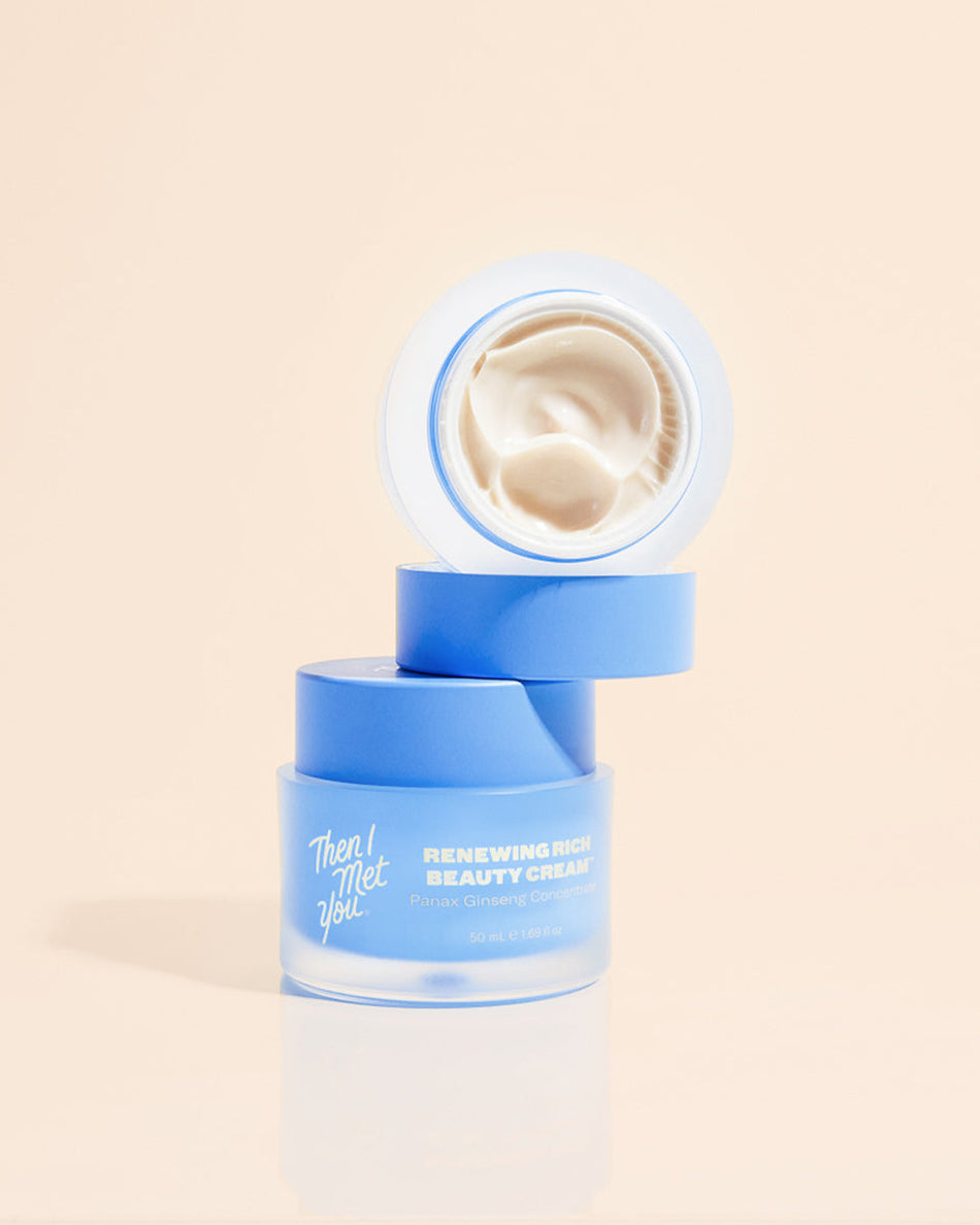Open jar of creamy white lotion with blue frosted glass and matching blue lid.